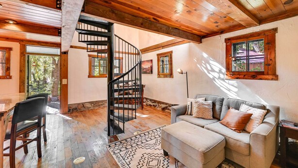 A spacious living area with a wooden staircase, a sofa, and a dining table. - Patio & Mtn Views: Peaceful Sedona Retreat (Sedona)