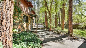 A rustic cabin with a stone exterior, surrounded by dense forest. - Patio & Mtn Views: Peaceful Sedona Retreat (Sedona)