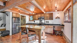 A kitchen with wooden cabinets, a stainless steel refrigerator, a microwave, and a dining table with chairs. - Patio & Mtn Views: Peaceful Sedona Retreat (Sedona)