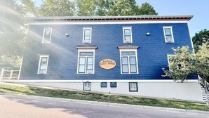 Un edificio de dos pisos con fachada azul y un letrero que dice 'The Bayfield Guest House'.