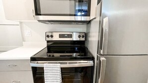 A kitchen with a stainless steel oven, microwave, and refrigerator. - South Shore Condo @ Bayfield Guest House (Bayfield)
