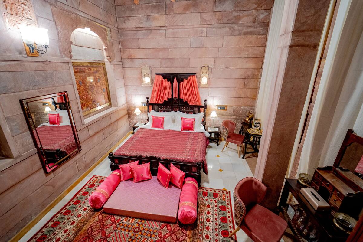 Ein traditionell eingerichteter Raum mit einem großen Bett, einer Sitzecke und einem kleinen Tisch.