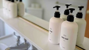 Handzeep en lotion flessen op een witte plank.