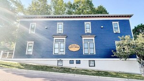 Un bâtiment à deux étages, à la façade bleue, sur lequel on peut lire l’inscription « The Bayfield Guest House », et dont les fenêtres sont encadrées de moulures blanches.