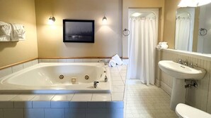 Une salle de bain moderne avec une grande baignoire, un lavabo et un espace douche.
