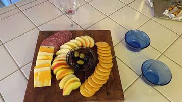 A charcuterie board with cheese, cured meats, apples, olives, and crackers on a wooden board.