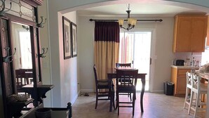 A spacious kitchen with a dining area, featuring a large island, wooden cabinets, and a tiled floor. - Auburn Party of 8 (Auburn)