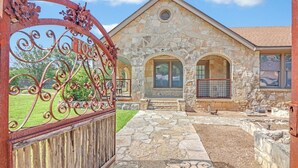 A stone building with a stone facade, a wooden fence, and a metal gate.
