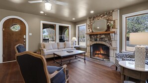 A cozy living room with a fireplace, a sofa, a coffee table, and a chair.