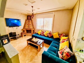 TV connectée, cheminée, livres, chaîne hi-fi
