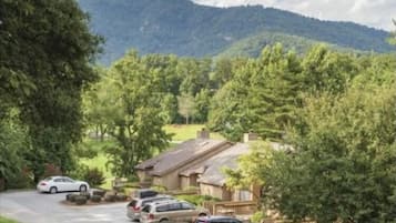 Zona residencial con casas, coches aparcados y montañas al fondo.