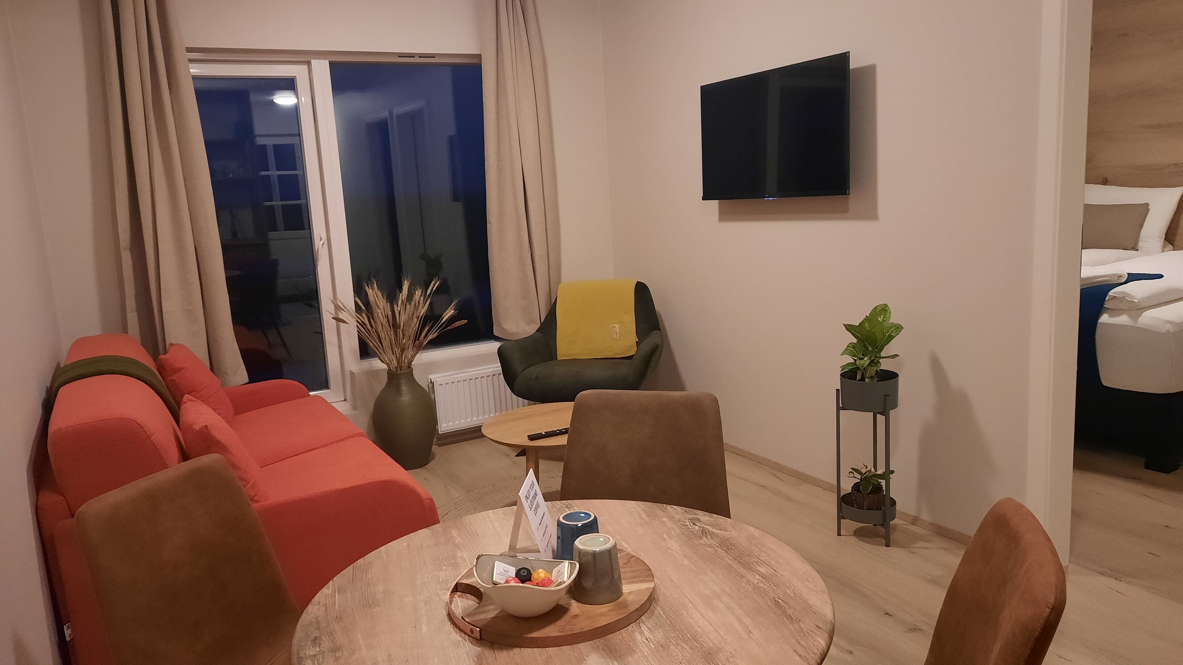A modern living room with a sofa, a coffee table, and a TV mounted on the wall.