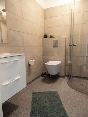 A bathroom with a toilet, sink, and shower.
