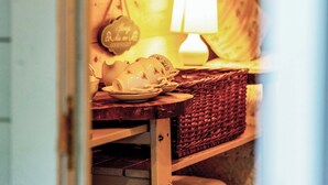 Ein gemütliches Zimmer mit einem Korbwäscher, einer Lampe und Wanddekoration.