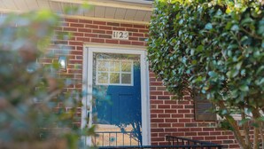 A brick building with a blue door and a number "1125" above it. - Rest Easy : King Bed : Downtown & Ft. Jackson 2Bd 1Bth (Columbia)
