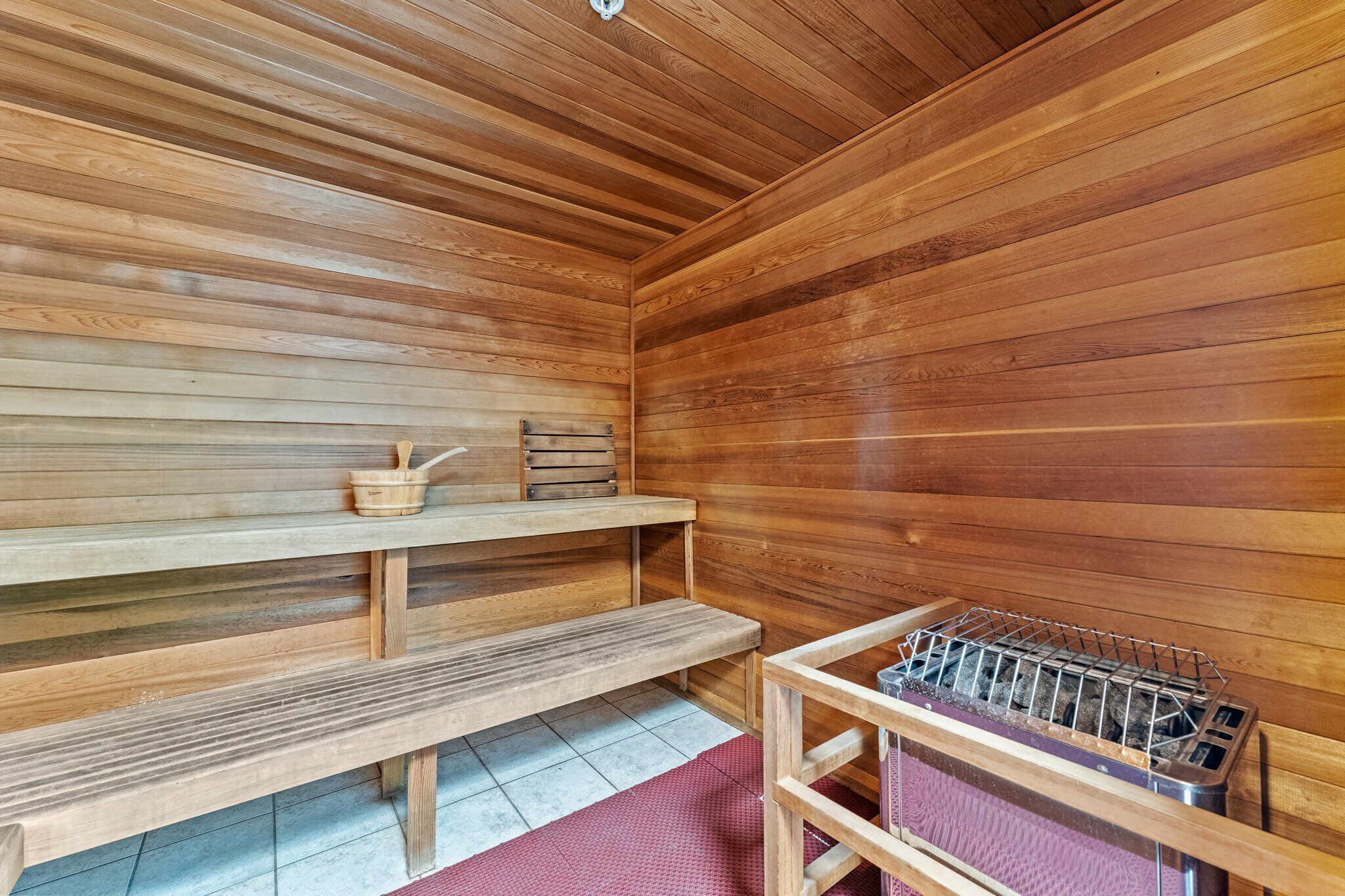 Een houten sauna met banken en een metalen rek.