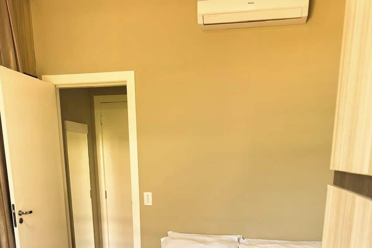 A hotel room with a bed, a desk, and a telephone.