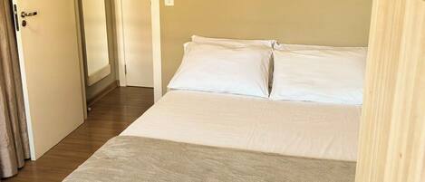 A hotel room with a bed, a desk, and a telephone.
