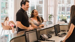 A modern office space with multiple workstations, large windows, and a glass partition. - Estação Termas Hotel (Piratuba)