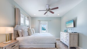 A bedroom with a bed, a nightstand, a dresser, a ceiling fan, and a TV. - Walk to the Beach ~ Golf Cart ~ Communal Pool (Santa Rosa Beach)