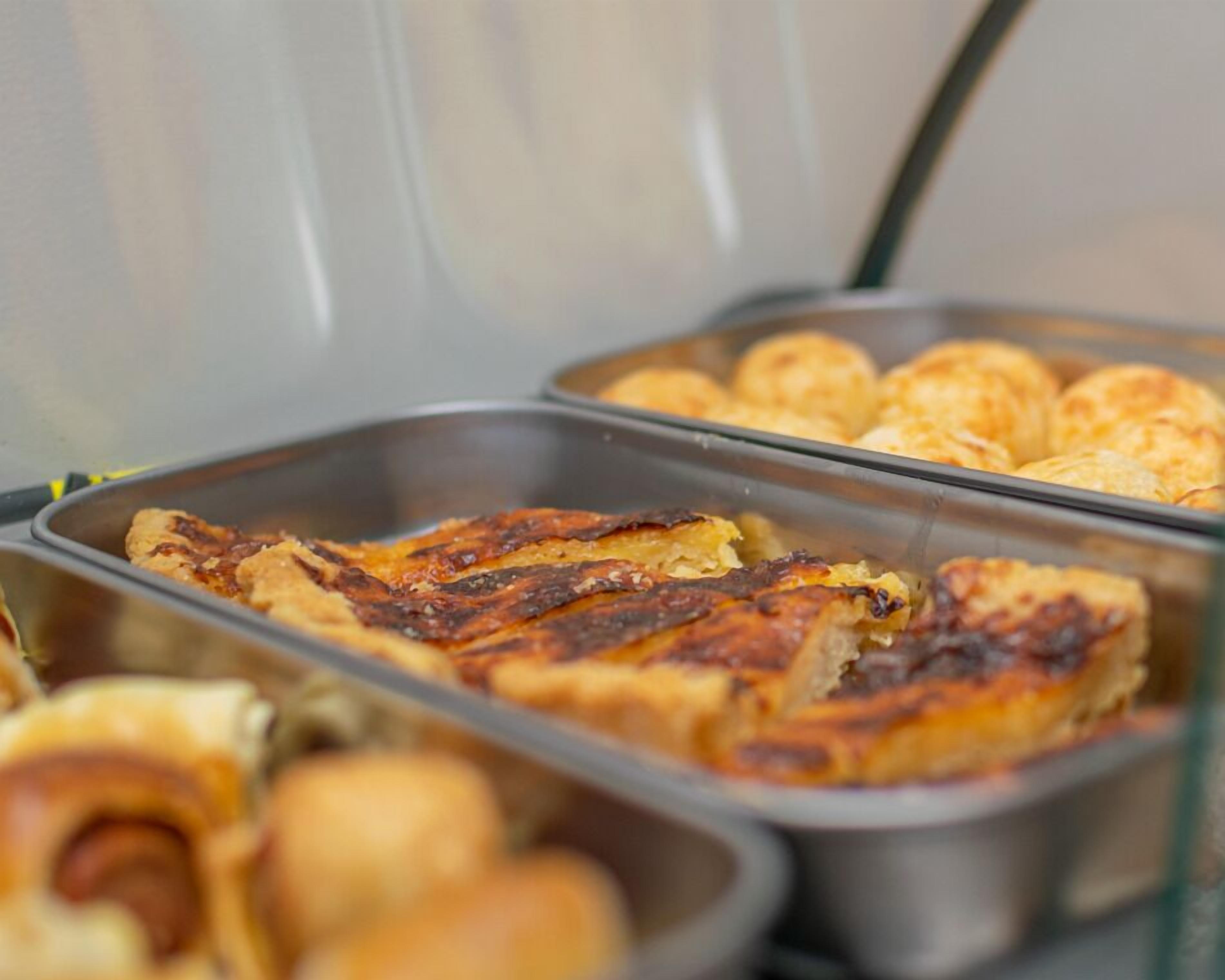 Un buffet con diversi piatti, tra cui carni alla griglia e dolci.