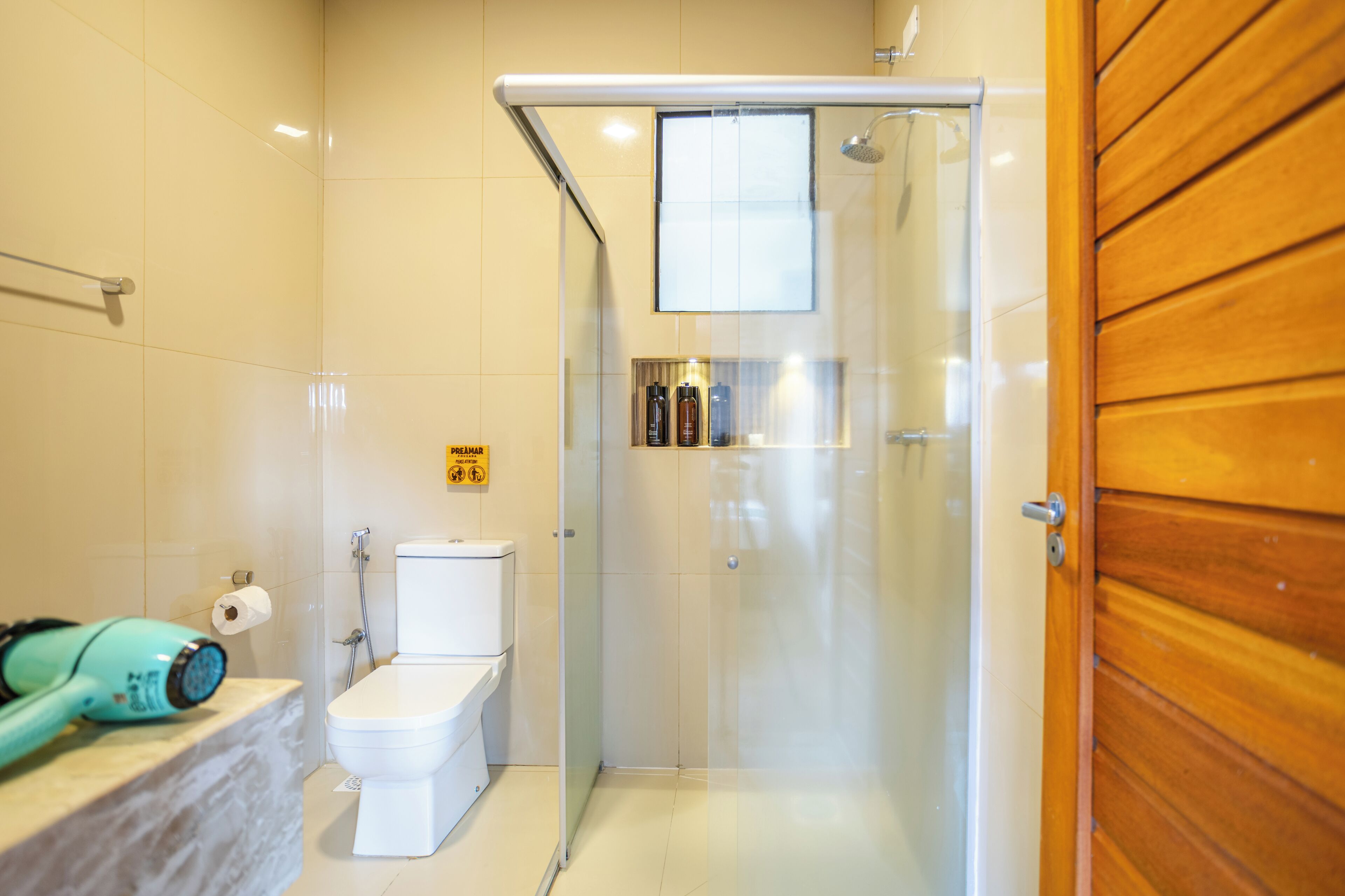Ein Badezimmer mit Toilette, Dusche und einer Glastür.