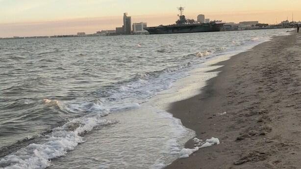 A beach with a ship in the background and footprints in the sand. - Lovely, beach view condo (Corpus Christi)
