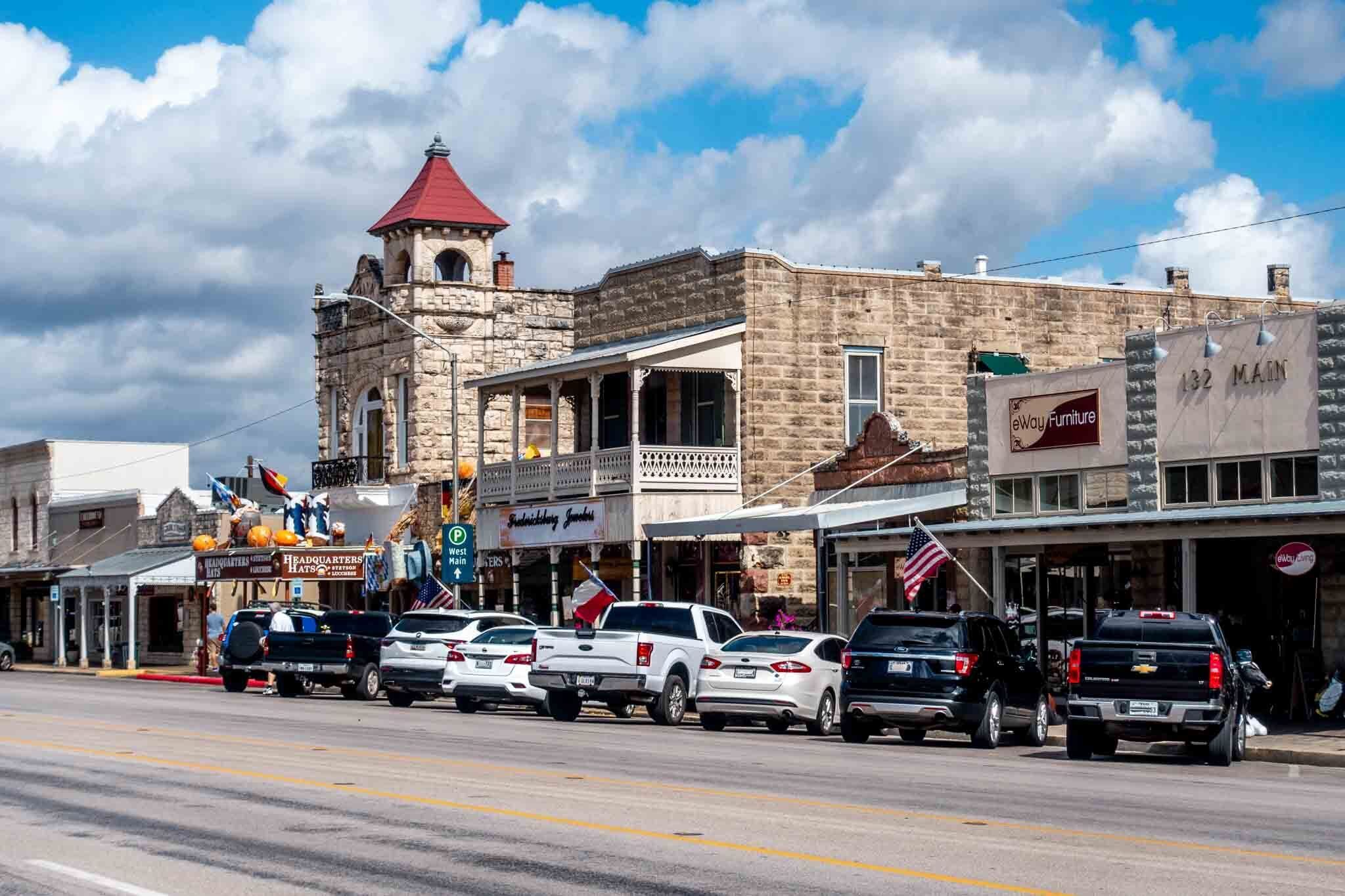 A street view with a historic building featuring a red roof and stone facade.