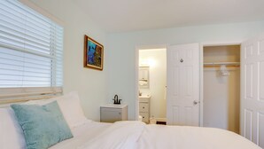 A bedroom with a bed, a nightstand, a bedside table, a closet, and a bathroom visible through an open door. - Pet-Friendly Stuart Studio < 3 Mi to Downtown! (Stuart)