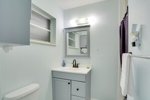 A bathroom with a white sink, a mirror, a window, and a shower curtain. - Pet-Friendly Stuart Studio < 3 Mi to Downtown! (Stuart)
