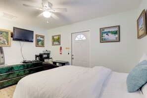 A hotel room with a bed, a desk with a computer, a flat-screen TV, and artwork on the walls. - Pet-Friendly Stuart Studio < 3 Mi to Downtown! (Stuart)