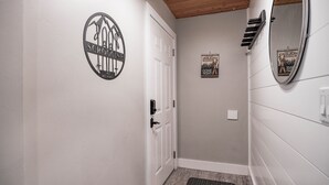 A hallway with a white door, a ski resort sign, and a ski lodge sign on the wall.