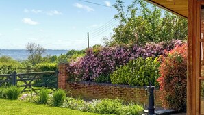 A garden with a brick wall, a wooden fence, and a water feature. - 3 bedroom accommodation in Ashbourne (Ashbourne)