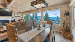 Une salle à manger spacieuse avec vue sur le lac Tahoe, un plafond en bois et une cheminée.