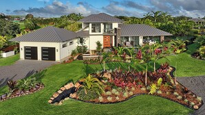 A modern two-story house with a well-maintained lawn and garden.