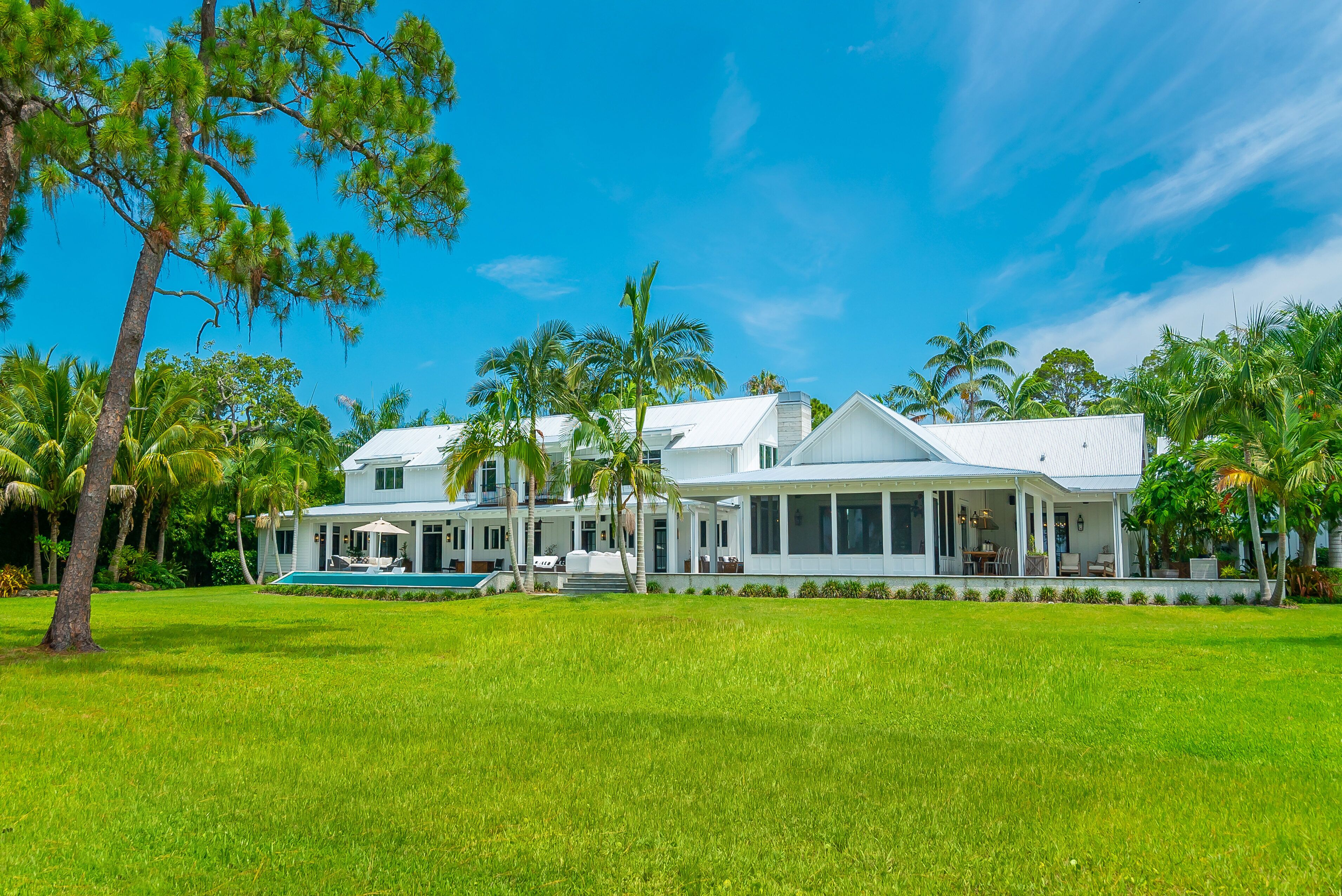 Rear view of main home and infinity edge pool area. Also, screened in porch. 