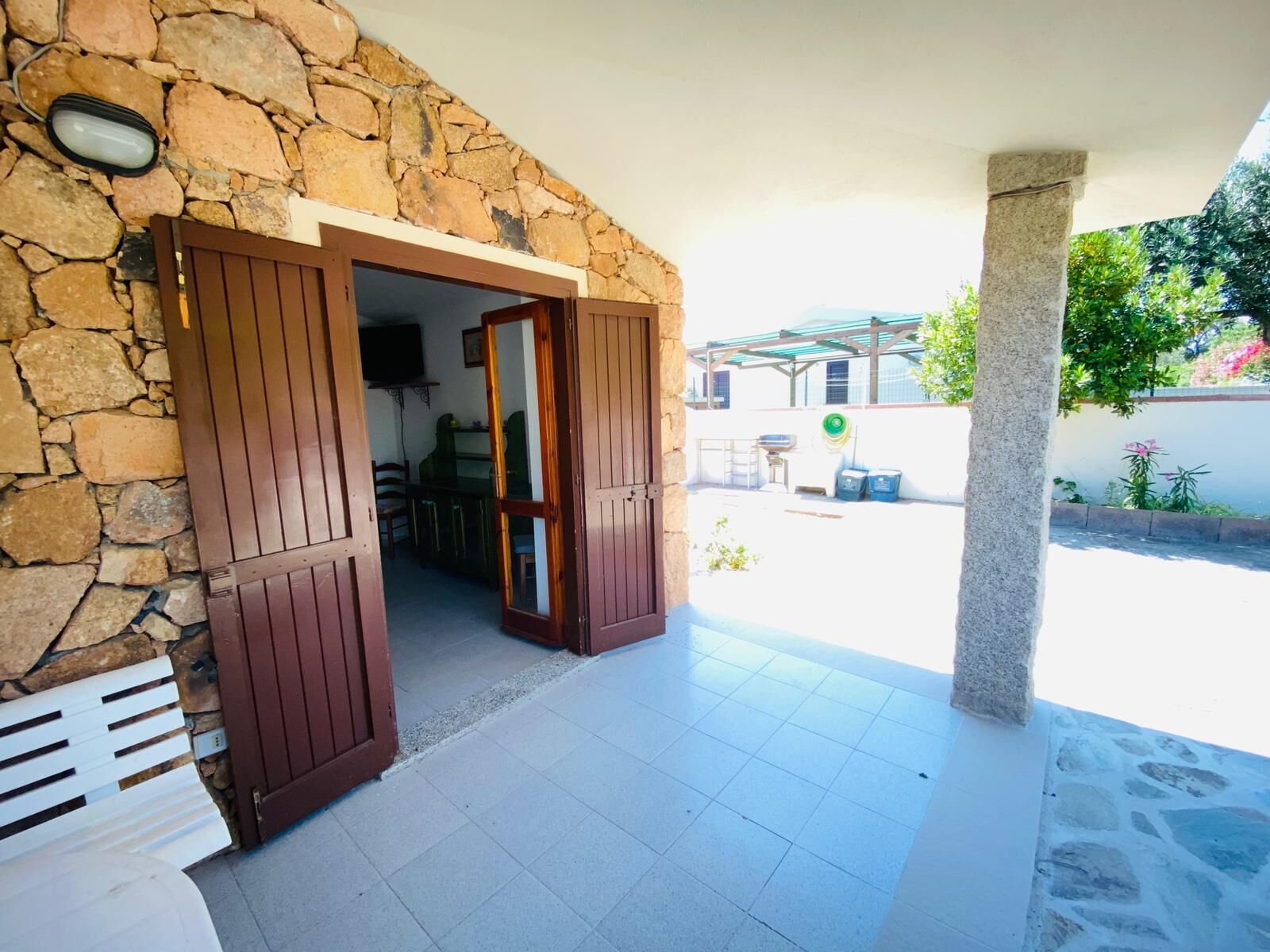 A stone-walled entrance with a wooden door leading to an outdoor patio area.