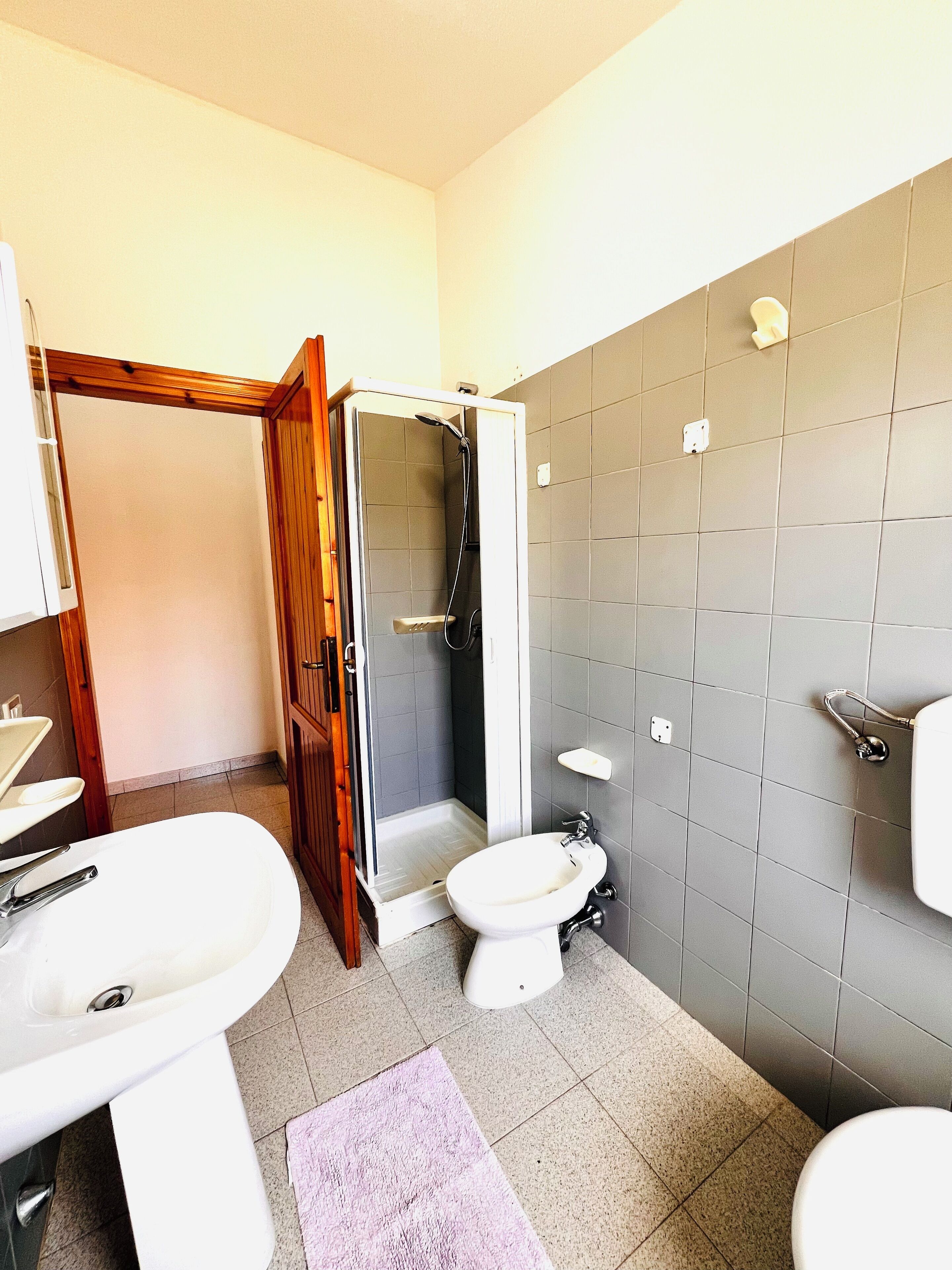 A bathroom with a shower, toilet, and sink.