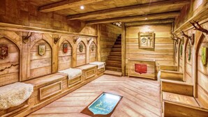 A wooden interior with benches and a staircase.