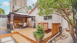 A wooden deck with outdoor furniture, a covered patio, and a potted plant. - Hidden Pearl Short Term Rental (Thunder Bay)
