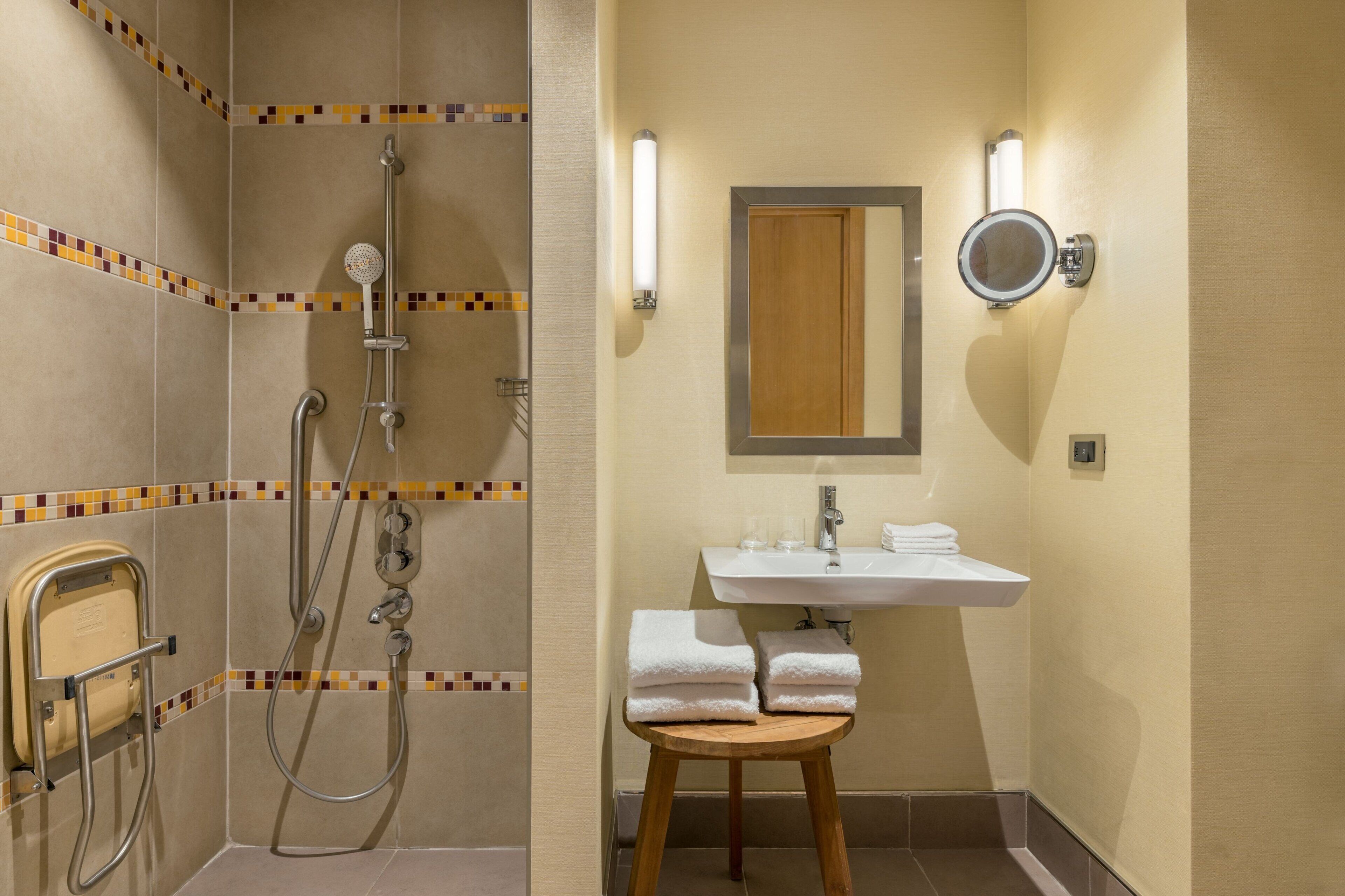 A bathroom with a shower, a sink, and a mirror.