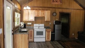 Una cocina pequeña con armarios de madera, estufa y refrigerador.