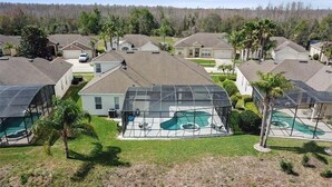 Un quartier résidentiel avec des maisons, une piscine et des panneaux solaires.