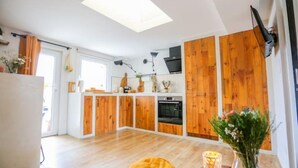 Una cocina moderna con armarios de madera, una isla central y un tragaluz.