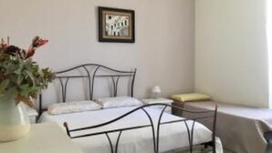 Ein Schlafzimmer mit Bett, Nachttisch, Lampe und einem gerahmten Bild an der Wand.