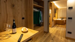 Interior de fusta amb taula, ampolla de vi, gots i comandament a distància.