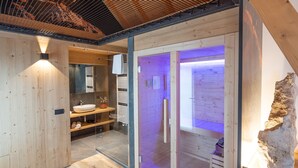 Un baño moderno con cabina de ducha de vidrio, paredes de madera y un área de lavamanos a la vista.