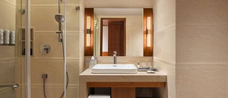 A modern bathroom with a glass-enclosed shower, a wooden vanity with a sink, and a mirror above it.