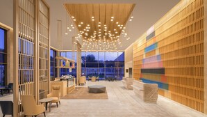 A modern interior with a central seating area, a bar, and a colorful wall.