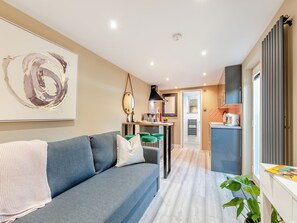 A modern living room with a grey sofa, a coffee table, and a large abstract painting.